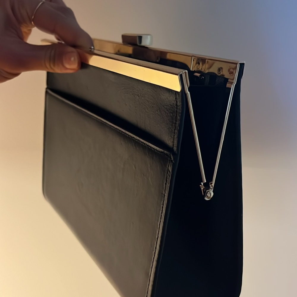 Black leather clutch with gold trim and checkered interior